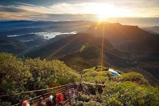 Iconic conical silhouette of Adam's Peak Sri Pada surrounded by clouds in Sri Lanka