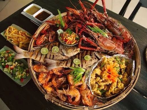 Piatto di pesce e frutti di mare servito sulla spiaggia di Negombo al tramonto