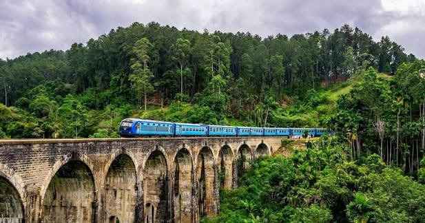 Iconic colonial Nine Arch Bridge in Ella on the Hill Country Sri Lanka with blue train