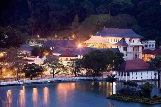 Vista notturna illuminata del Tempio del Dente e del suo riflesso sul Lago di Kandy