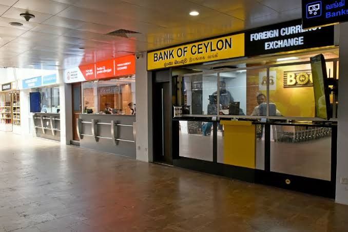 International travelers exchanging currency at Bandaranaike International Airport in Sri Lanka.