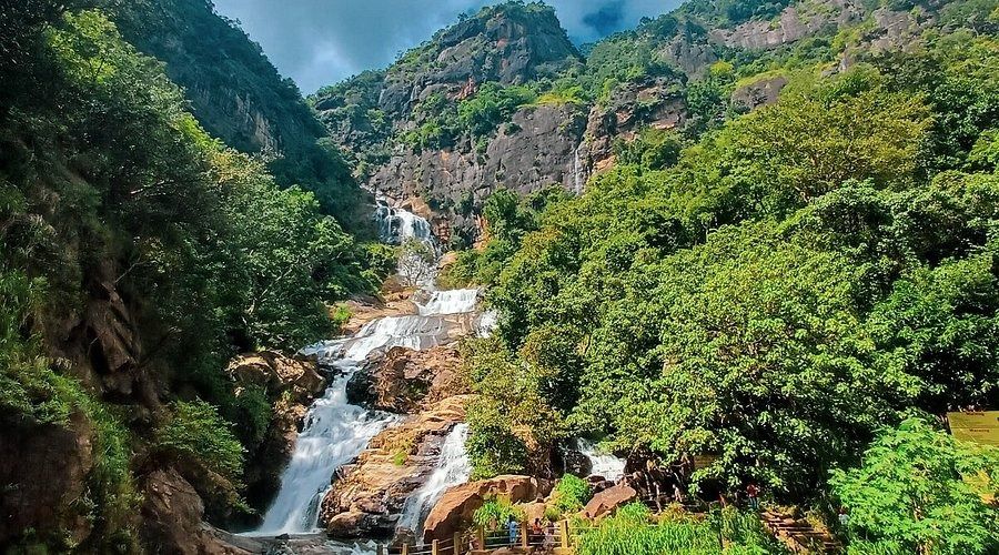 Scenic view of Ravana Falls cascading down a curved rock amphitheater in Ella.