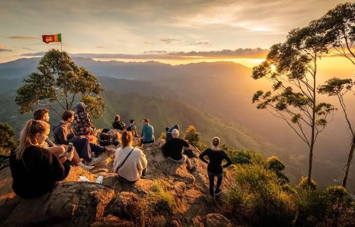 Hikers standing atop the high cliffs of Ella Rock overlooking the valley.