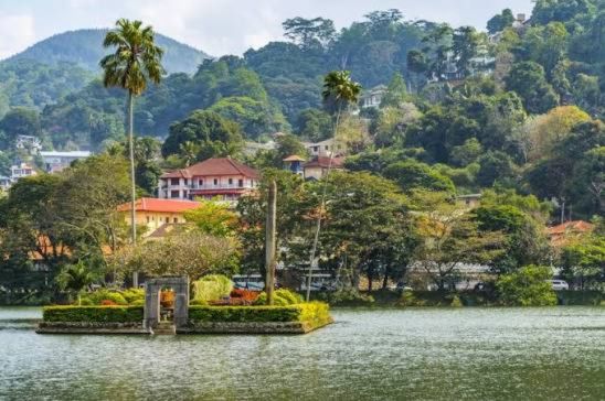 Panoramic view of Kandy city center, Kandy Lake, and the surrounding green hills in Sri Lanka.