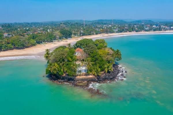 Aerial view of Taprobane Island surrounded by turquoise water in Weligama Bay Sri Lanka.