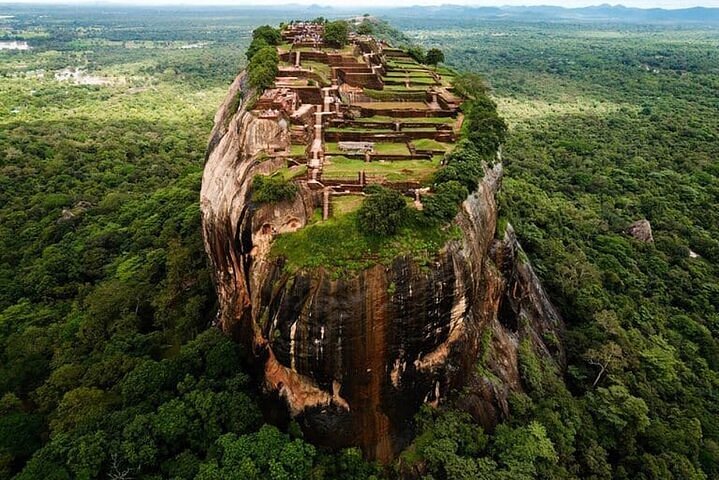 Aerial view of Sigiriya Lion Rock fortress standing above the central jungle canopy.