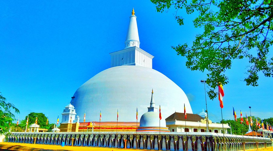 The magnificent gleaming white dome of Ruwanwelisaya Stupa surrounded by pilgrims in Anuradhapura.