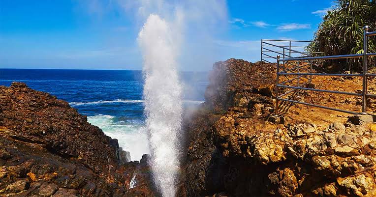 Powerful jet of water erupting from the Hummanaya natural blowhole at Kudawella against a blue sky